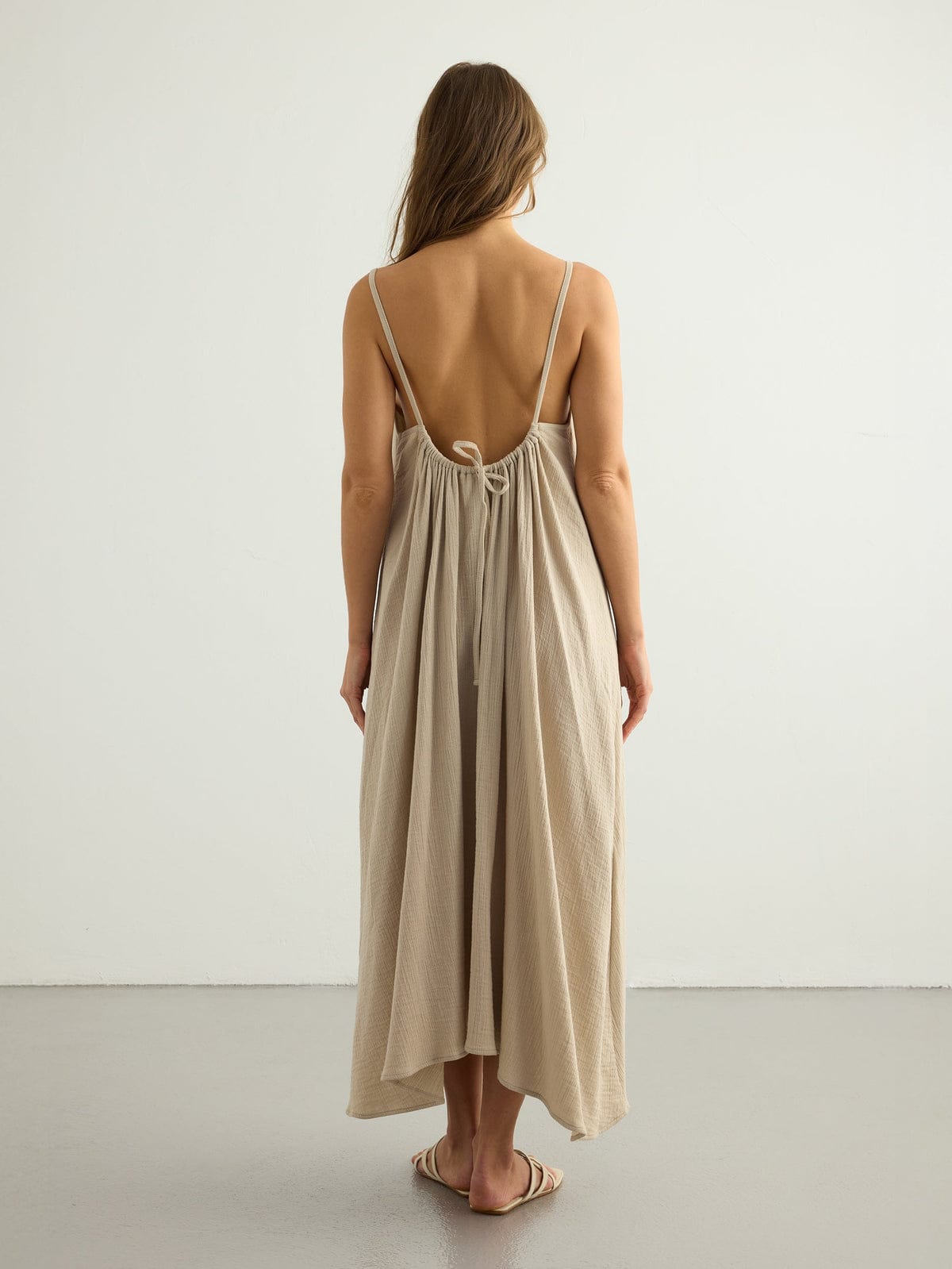 Nextry.pk backless maxi dress in flowing fabric with a fitted bodice and open back, perfect for elegant summer occasions.