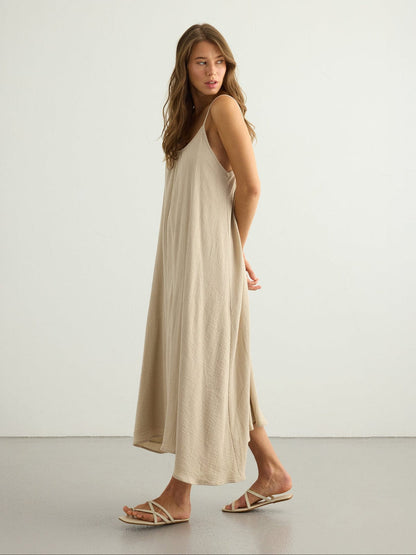 Oatmeal backless maxi dress by Nextry.pk, flowing fabric with a stylish open-back design perfect for casual or formal wear.