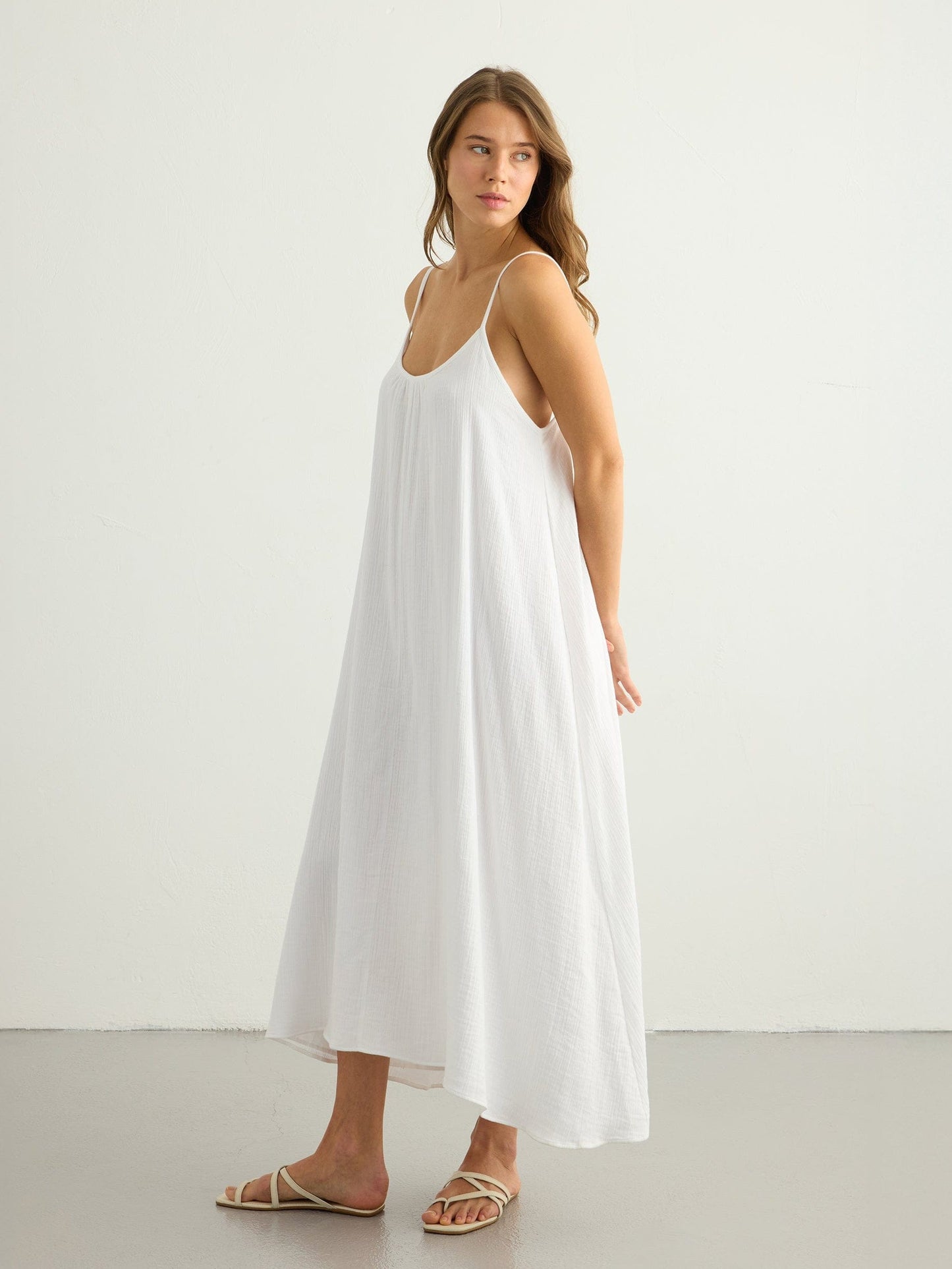 White Back Less Maxi Dress by Nextry.pk featuring a flowing fabric and open back design, perfect for elegant summer occasions.